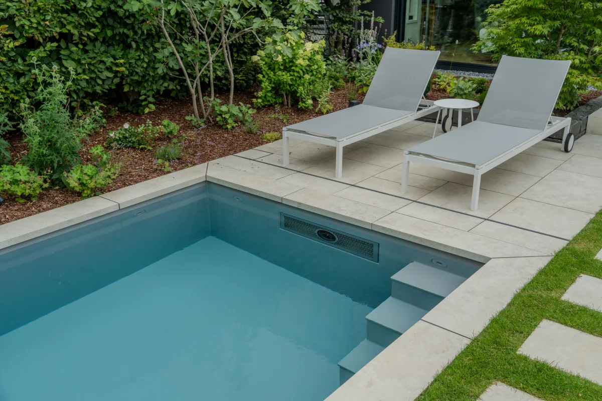 Draufsicht auf einen Pool mit Salzelektroliese, umradet von Keramikplatten.