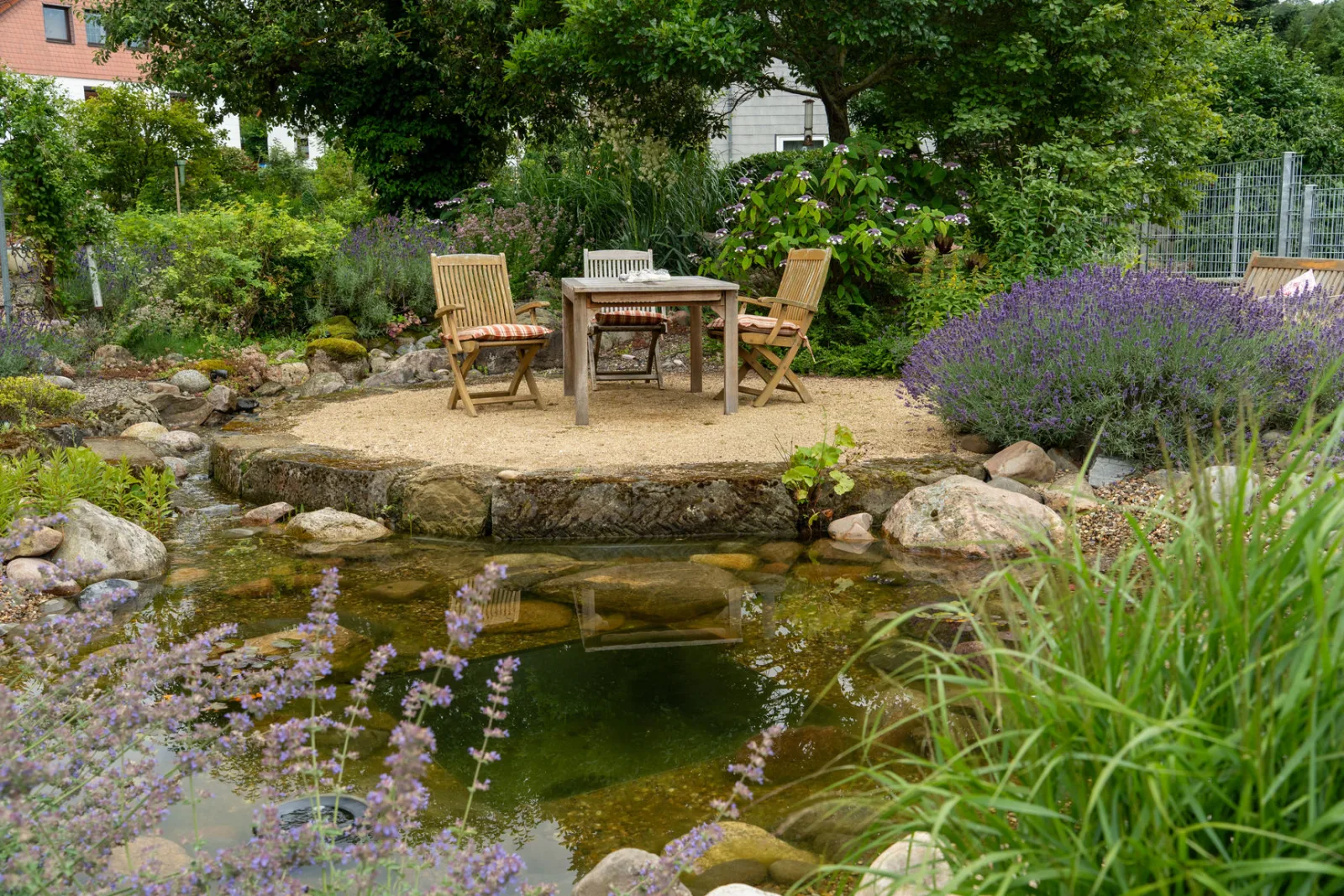 Gartenteich mit Sitzinsel in der Mitte.