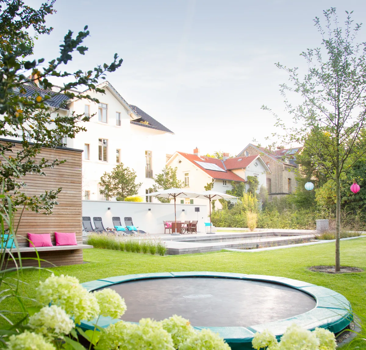 Ebenerdiges Trampolin in einer modernen Gartenumgebung.