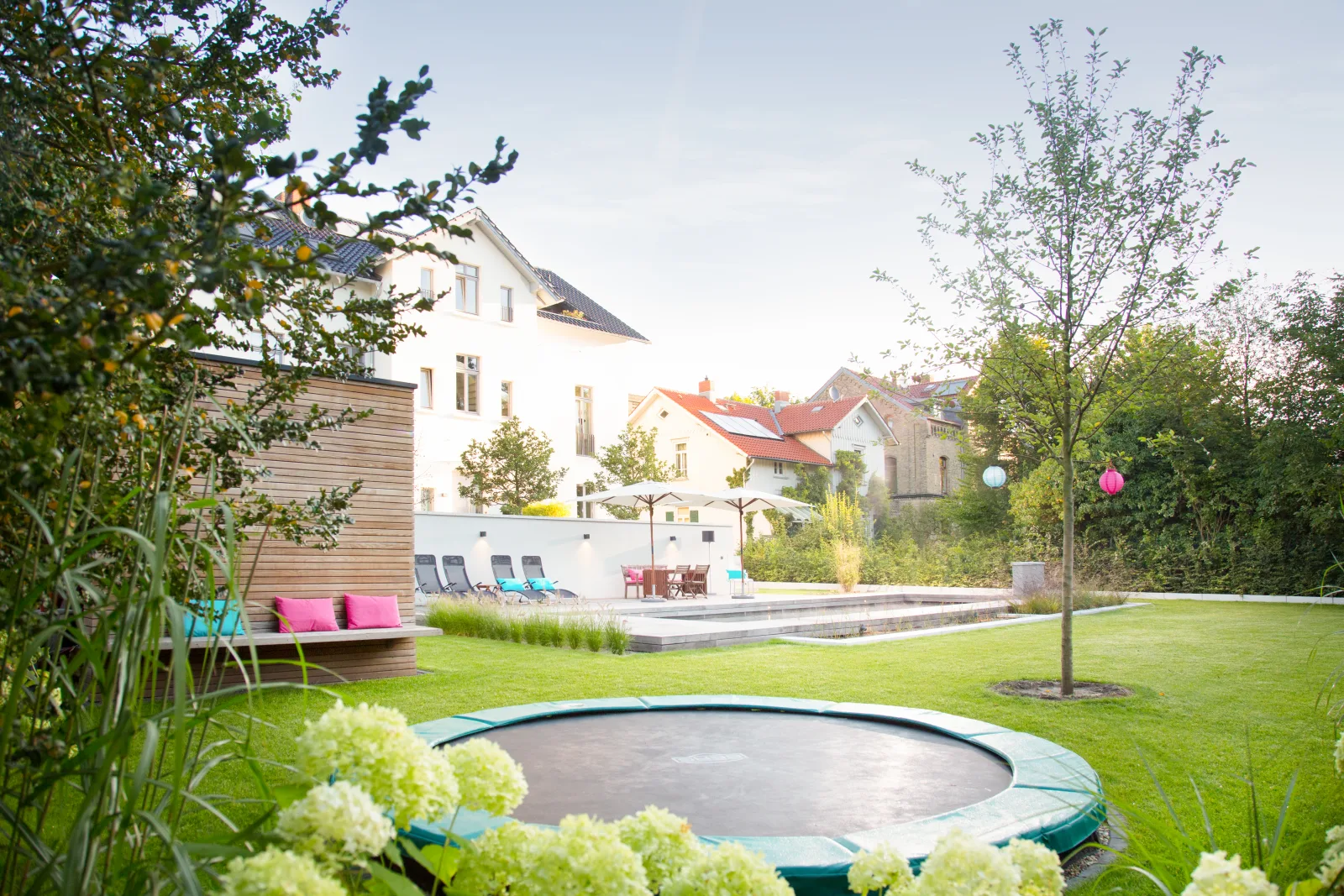 Ebenerdiges Trampolin in einer modernen Gartenumgebung.